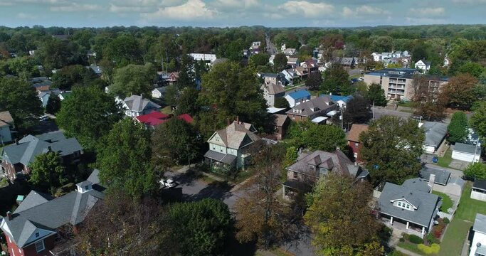 A daytime slow reverse aerial establishing shot of a typical residential neighborhood in Salem, Ohio. Tilt up to timelapse clouds.	