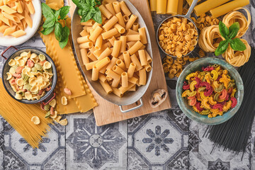 Pasta. italian pasta. Variety of traditional italian pasta: colorful spaghetti, tagliatelle, farfalle, penne, ptititm, noodle, fusilli, cannelloni on an old stone background. Top view with copy space.