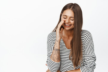 Beautiful woman laughing, natural expression, girl having fun, reaction to smth funny, standing against white background