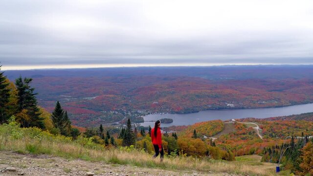 Mont Tremblant, Laurentians, Quebec, Canada. Woman hiking on mountain enjoying view and autumn fall foliage colorful forest