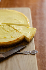 a piece of cheesecake on a wooden board on the table
