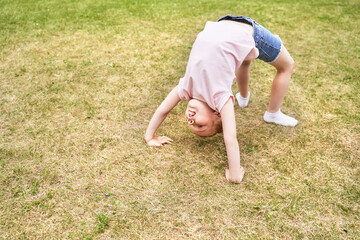 Pretty face. Red hair. Cute school child doing yoga exercise. Active vacation. Small people in bridge pose. Online video call. Happy children concept. Lifestyle action. Watching sport lesson