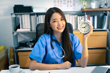 Portrait shot of female doctor with office clock in doctor’s office.
