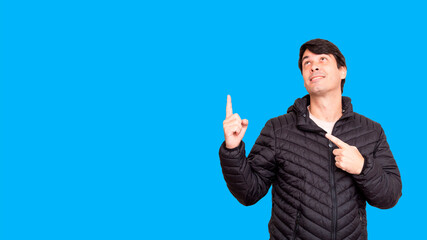 Man in black jacket looking up and pointing up. Indicating a direction.