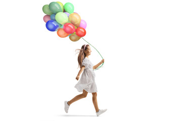 Girl in white dress running and holding a bunch of balloons