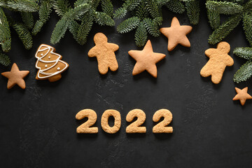 Christmas holidays glazed cookies and date 2022 on a black background. Happy New Year. View from above. Flat lay.