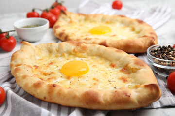 Fresh delicious Adjarian khachapuris on table, closeup