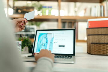 Crop woman making payment with plastic card during online shopping