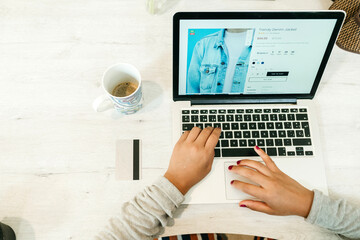 Woman browsing laptop during online shopping at home