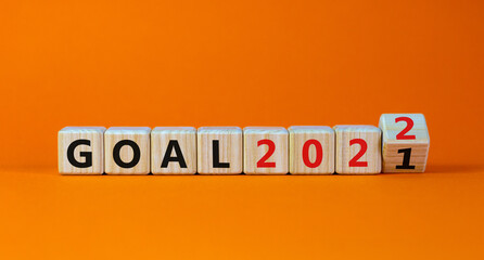 Planning 2022 goal new year symbol. Turned a wooden cube and changed words 'Goal 2021' to 'Goal 2022'. Beautiful orange background, copy space. Business, 2022 goal new year concept.