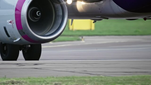 The wheels of the plane go on the runway of the airport. The plane goes to the runway. Slow motion video of airport life.