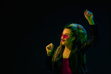 young woman with dreadlocks in red sunglasses dancing