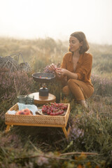 Woman traveler has a beautiful berakfast time with eggs and fruits while traveling in mountains on foggy weather