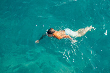person bathing at the sea blue water
