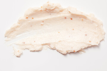 Face cream scrub texture background. Exfoliating skin care product swatch smear smudge. Gentle creamy scrub cleanser sample close up
