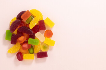Fruit gummy or jelly candies on a pastel background top view with copy space