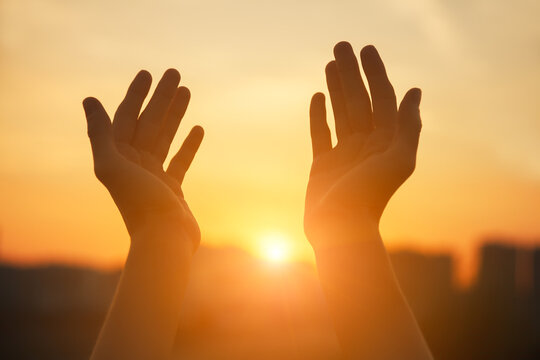 Praying hands at sunset light, spiritual soul, religion concept
