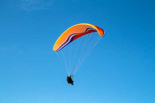 Voando de parapente com c&eacute;u azul