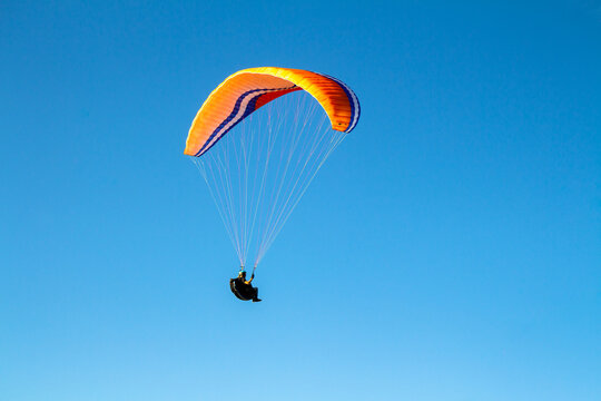 Voando de parapente com c&eacute;u azul