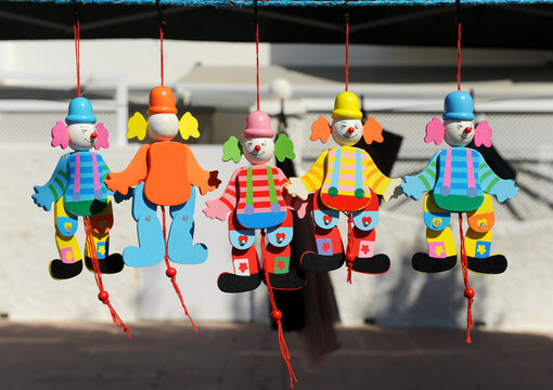 Mu&ntilde;ecos articulados de madera de payasos de colores a la venta en un mercadillo de artesan&iacute;a.  Payaso buf&oacute;n artesanal de madera. Juguetes marionetas para ni&ntilde;os.
