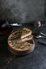 Caramel cake with chocolate icing on a dark table. Food photography in dark style.