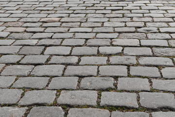 Old cobblestone pavement close-up. Cobblestone sidewalk background. Soft focus