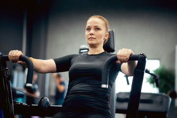 A woman is engaged in fitness in the gym to lose weight and burn extra calories, a healthy...