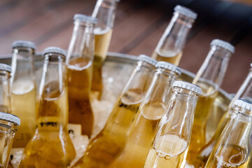 Cold lager beer bottles in ice bucket, closeup