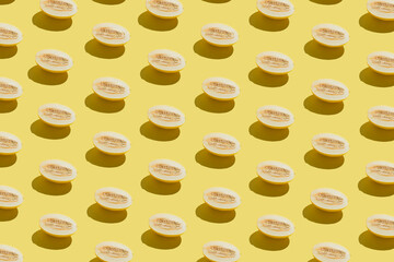 Creative bright pattern made with fresh melon on yellow background. Minimal sunlit isometric.