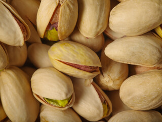 Pistachio nuts. Whole and open Close-ups. Macro photography. Confectionery, beer snack. A healthy vegetarian product. Background. Wallpaper. Texture. There are no people in the photo.
