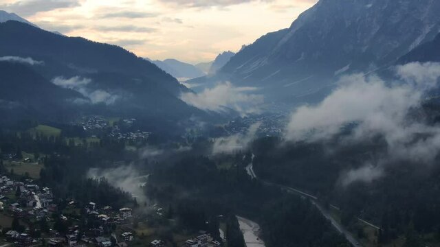 Sunset flight over Borca di Cadore village in the Dolomites mountains, Italy