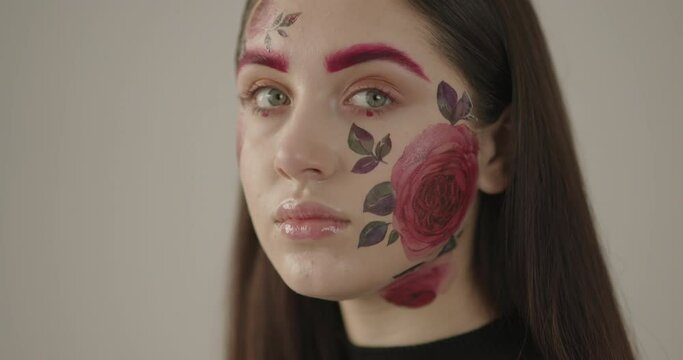 close-up of a young beautiful girl whose face is beautifully painted with flowers