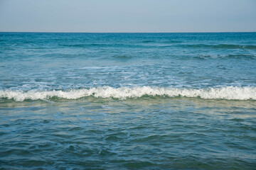 Sea or ocean tropical landscape view. Sea waves under the sun. Summer vacation and travel concept. Water wave surface. Sand beach. 