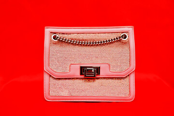 a handbag kept against a plain red background