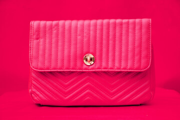 a handbag kept against a plain pink background