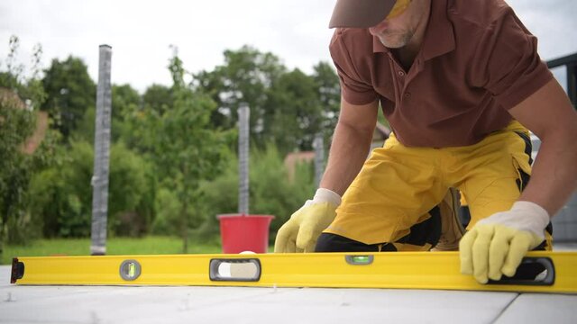 Concrete Bricks Patio Floor Paving by Worker with Soft Elastic Hummer