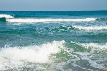 Sea or ocean tropical landscape view. Sea waves under the sun. Summer vacation and travel concept. Water wave surface. Sand beach. 