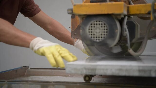 Worker Cutting Concrete Path Tiles Using Powerful Saw
