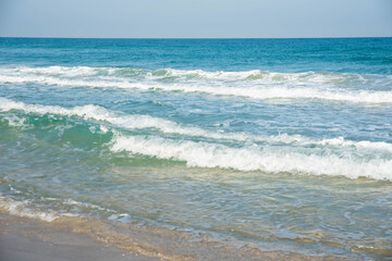 Sea or ocean tropical landscape view. Sea waves under the sun. Summer vacation and travel concept. Water wave surface. Sand beach. 