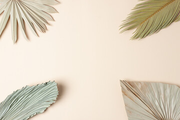 Tropical background with palm leaf on pastel beige. Flat lay, copy space
