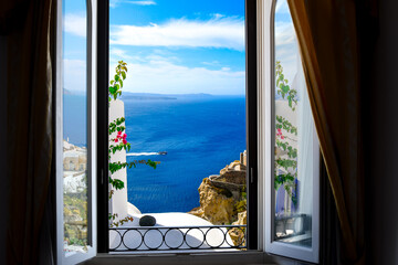 View of the Aegean Sea, caldera, cliffs and whitewashed buildings from a room's window in Oia,...