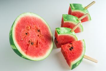 Sliced ripe juicy watermelon. Watermelon slices with wooden sticks.