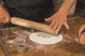 Worker preparing typical Mexican sweets made from Alfe&ntilde;ique, used during the Dia de Muertos festival to put on altars. The person's hands and the molds and the dough are distinguished.