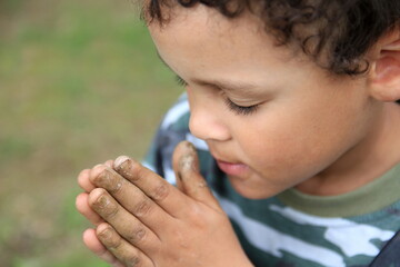 little boy praying to God with hands together stock photo