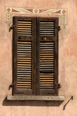 Shutters set in pink-rendered wall of italianate house, Swiss canton of Grisons