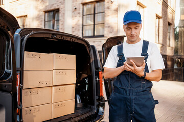 Express service a man in a uniform delivers boxes. The employee carries the order home to the...