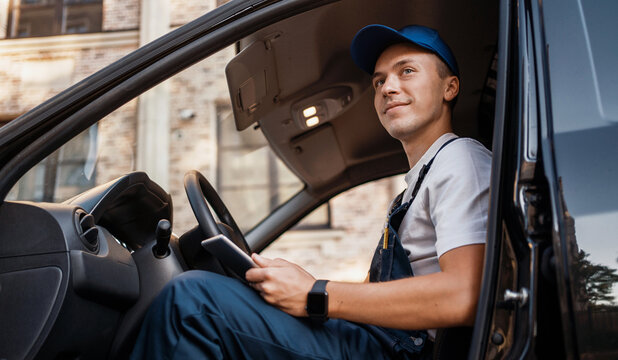 The employee takes the order home to the client. Express service a male driver in uniform delivers boxes. Courier service for the delivery of goods.