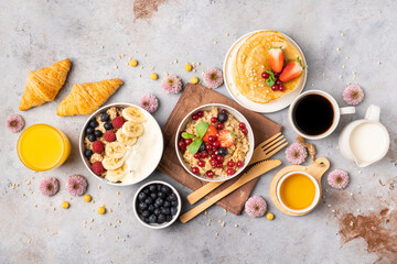  Beautifully served table for breakfast with many delicacies, cheeses, salami, pastries, orange juice, tea and coffee.
