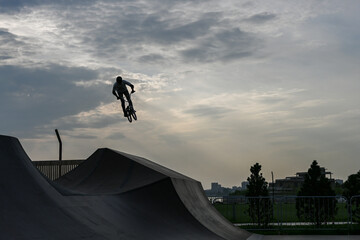 The cyclist rides in an extreme park. The stuntman. The skate park, rollerdrome, quarter and half...