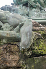 Fototapeta na wymiar Antwerpen, Belgium - August 1, 2021: Green bronze Brabo statue on Grote Markt. Closeup of detail: the hand-less arm of giant Antigoon.